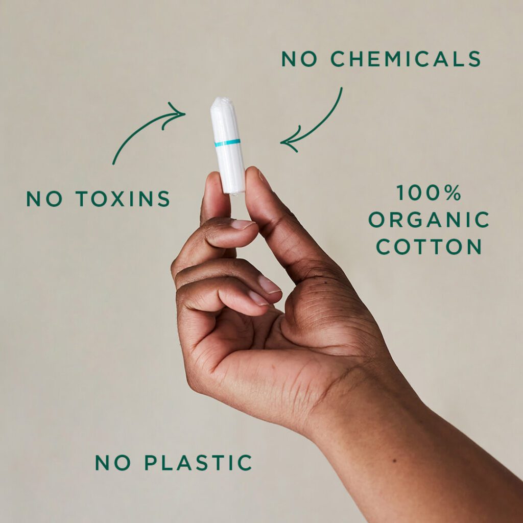 Black Woman Holding Up A Dame Organic Cotton Tampon With Diagram - No Plastic, 100% Cotton, No Chemicals, No Toxins