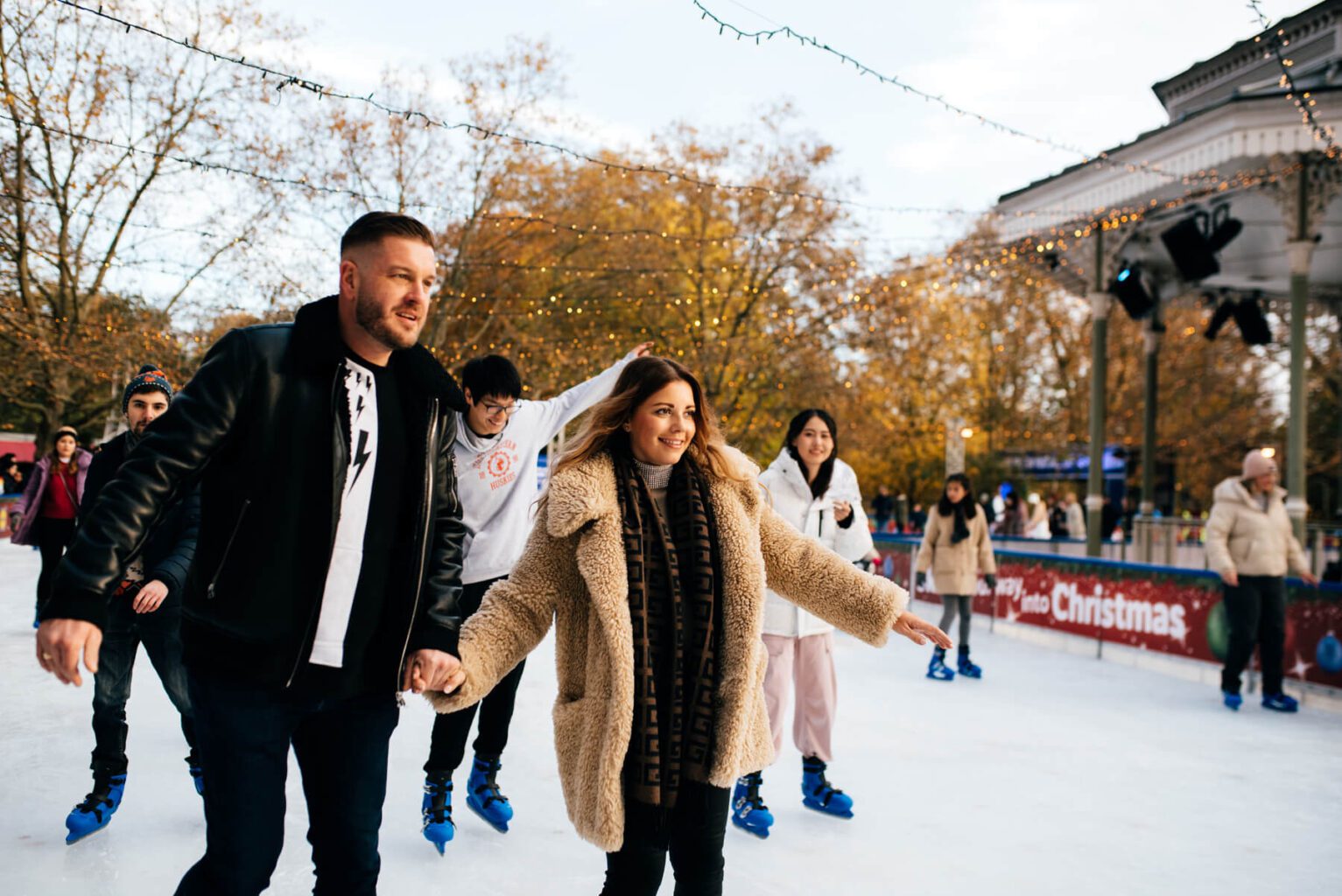 Couple Ice Skating Hand-in-Hand in Hyde Park Winter Wonderland Ice Rink