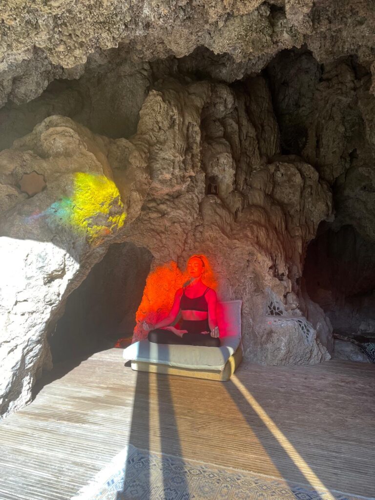 The Women's Journal founder Jennifer Read-Dominguez meditating in a cave at Molino del Rey, bathed in coloured sunlight during a yoga retreat in Andalusia