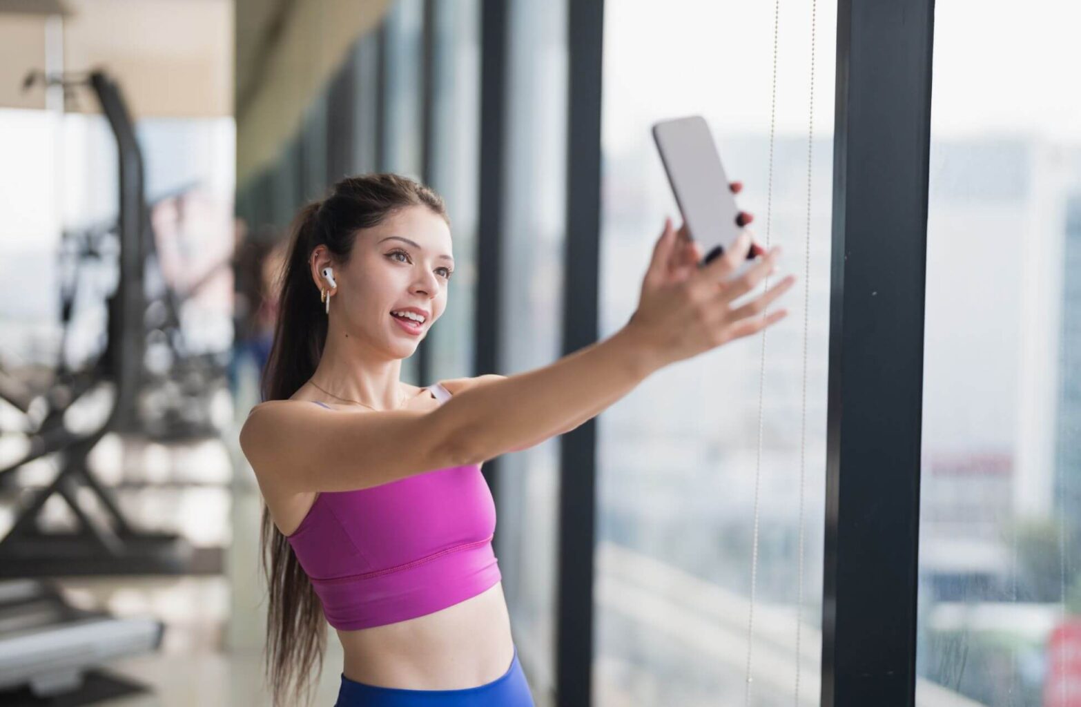 Fitness influencer woman taking a selfie in the gym, representing Gen Z content creators and side hustle culture in the UK