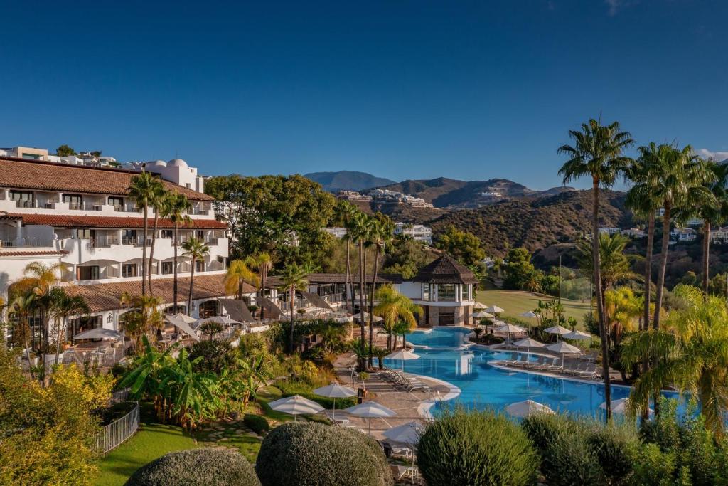 The Westin La Quinta Golf Resort & Spa in Benahavís near Marbella, featuring the outdoor swimming pool, palm-lined gardens, and views over the golf course and surrounding mountains.